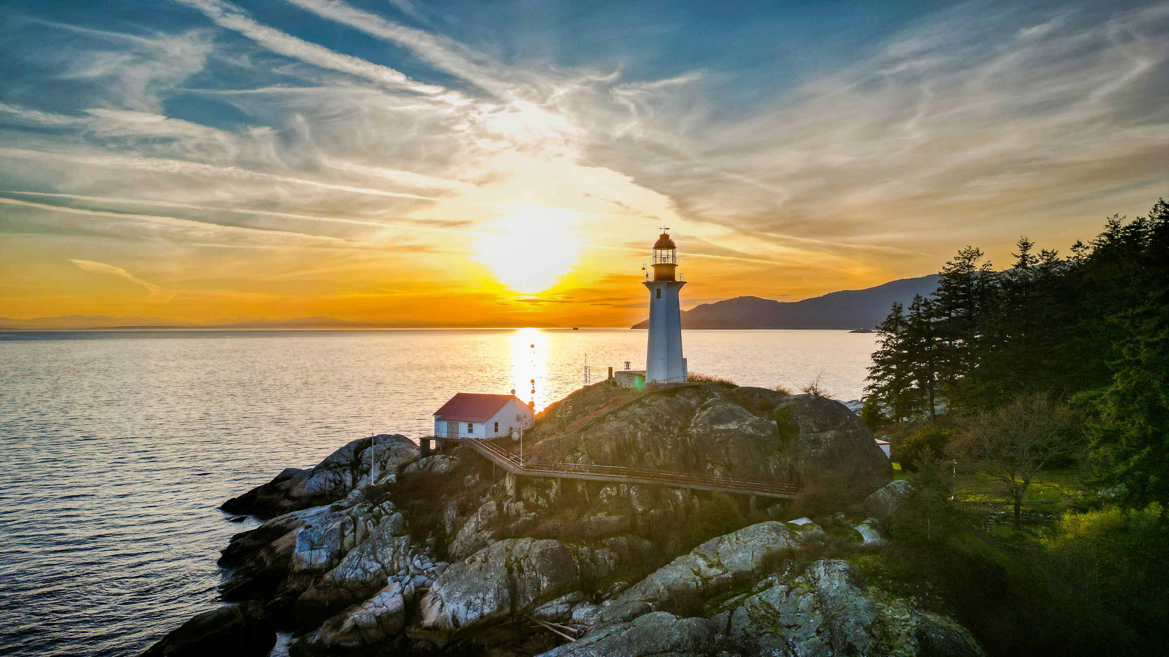 A lighthouse overlooking the ocean in the warm light of sunset